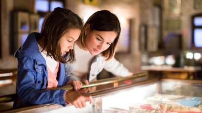 A mother and daughter looking at displays at one of the Savannah museums.